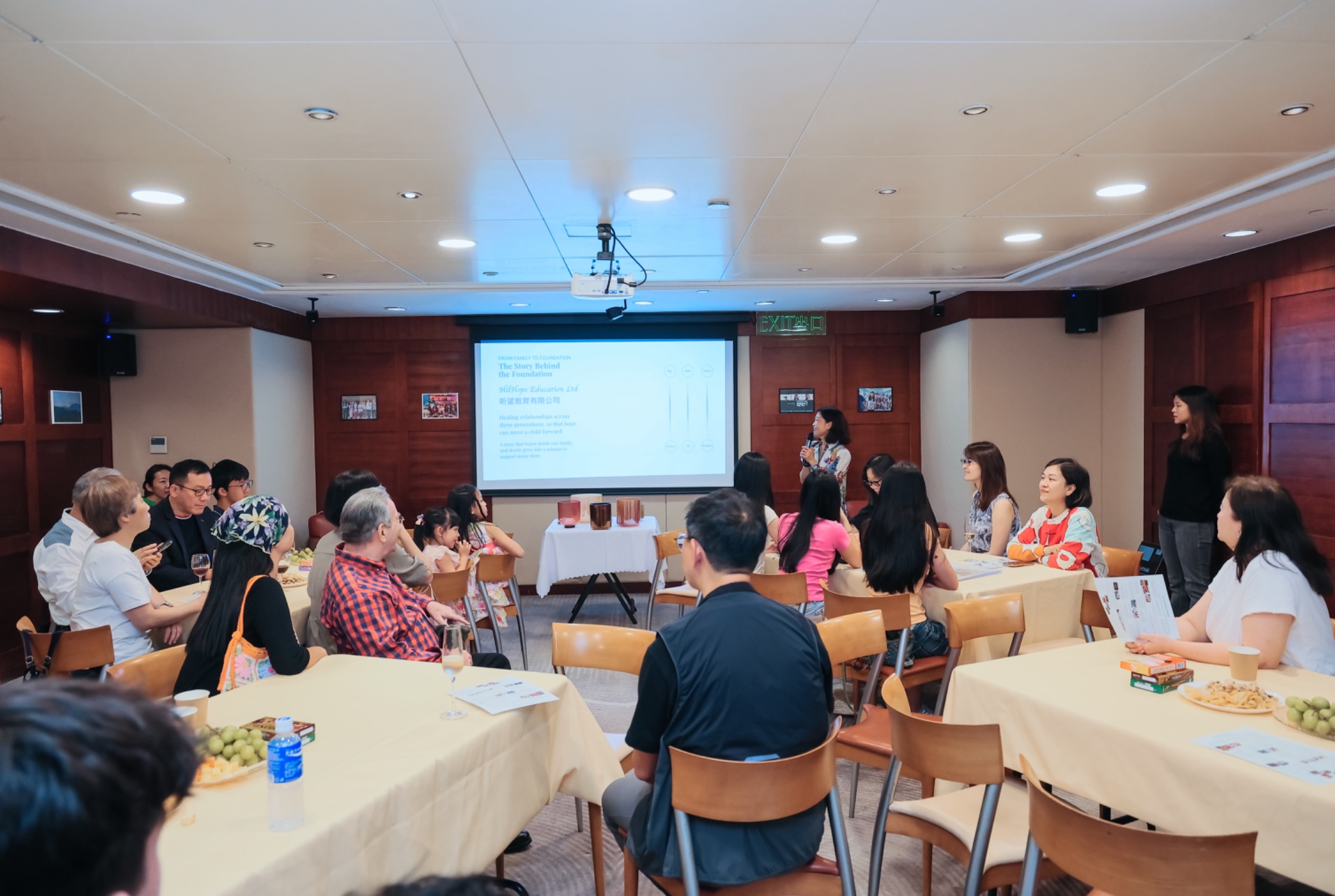 A speaker sharing the story behind the organization with seated guests